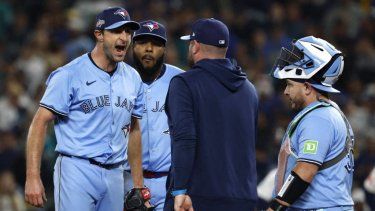 El mánager John Schneider #14 de los Toronto Blue Jays camina hacia el montículo para hablar con Max Scherzer #31 durante la quinta entrada contra los Seattle Mariners en el cuarto juego de la Serie de Campeonato de la Liga Americana en el T-Mobile Park el 16 de octubre de 2025 en Seattle, Washington. 
