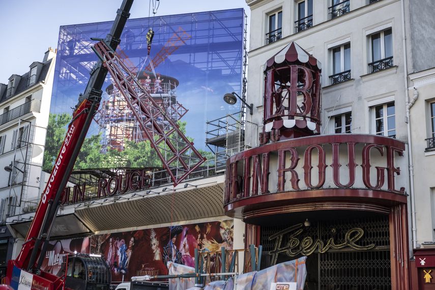 Esta fotografía muestra una grúa que levanta una de las cuatro velas temporales del molino de viento durante su instalación en la parte superior del cabaret Moulin Rouge tras el colapso de las anteriores, en París el 24 de junio de 2024.