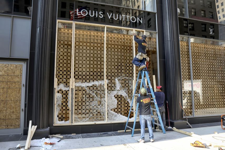 Trabajadores cubren con tablones la vidriera de una tienda de la cadena Louis Vuitton en la ciudad de Chicago. &nbsp; &nbsp;