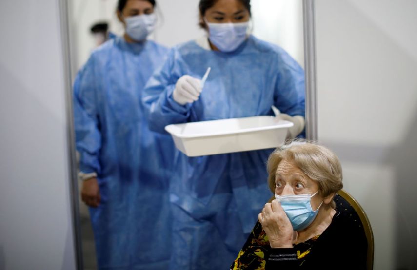 Personal médico se dispone vacunar a una anciana en Buenos Aires, en Argentina.
