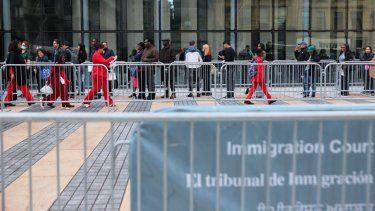 Migrantes esperan en fila para entrar al tribunal de inmigración en el Edificio Federal Jacob K. Javits el 22 de octubre de 2025 en la ciudad de Nueva York.
