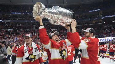 El defensa de los Florida Panthers, Brandon Montour, centro, levanta el trofeo de la Copa Stanley después del Juego 7 de la final de la Copa Stanley de hockey de la NHL contra los Edmonton Oilers, el lunes 24 de junio de 2024, en Sunrise, Florida. Los Panthers derrotaron a los Oilers 2-1. 