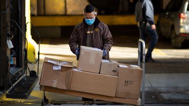Un empleado de la compañía UPS organiza paquetes para su distribución.