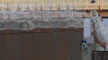 Un migrante haitiano sube la valla fronteriza entre México y Estados Unidos cerca del cruce fronterizo de El Paso, en Ciudad Juárez, estado de Chihuahua, México, el 15 de abril de 2021. &nbsp; &nbsp;