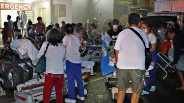 Residentes y personal médico evacuan a pacientes del interior de un hospital después de que un terremoto de magnitud 7,6 sacudiera la ciudad de Butuan, en la isla sur de Mindanao, el 2 de diciembre de 2023.