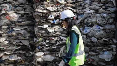 Una empleada camina este martes junto a un contenedor repleto de plástico en Puerto Klang en Selangor (Malasia).&nbsp; 