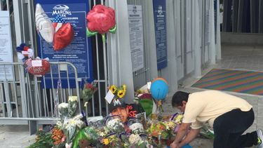 Un hombre escribe sobre una camiseta en el lugar donde los vecinos de La Pequeña Habana decidieron rendir homenaje al fallecido lanzador José Fernández, en el Marlins Park.