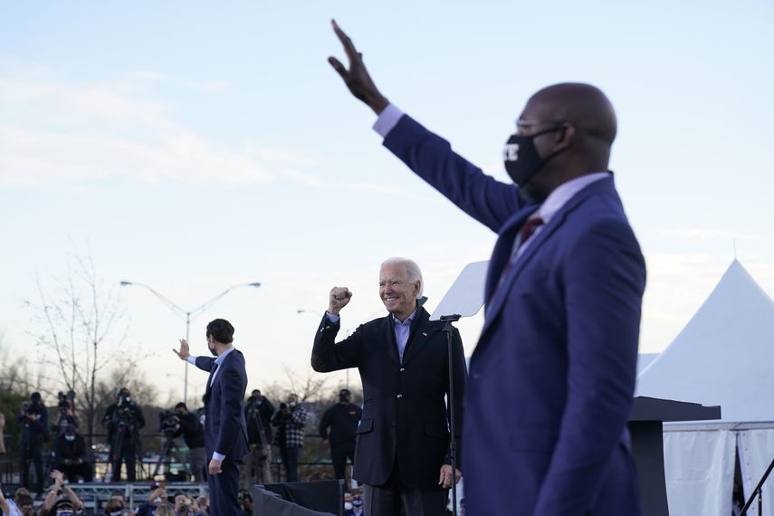 El presidente electo de Estados Unidos, Joe Biden, durante un acto de campaña en Atlanta, el 4 de enero de 2021, con los candidatos demócratas en dos balotajes al Senado, Raphael Warnock (derecha) y Jon Ossoff (izquierda).&nbsp;