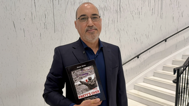 El historiador Omar Sixto sostiene su libro Se acabó la diversión durante la presentación en Miami.