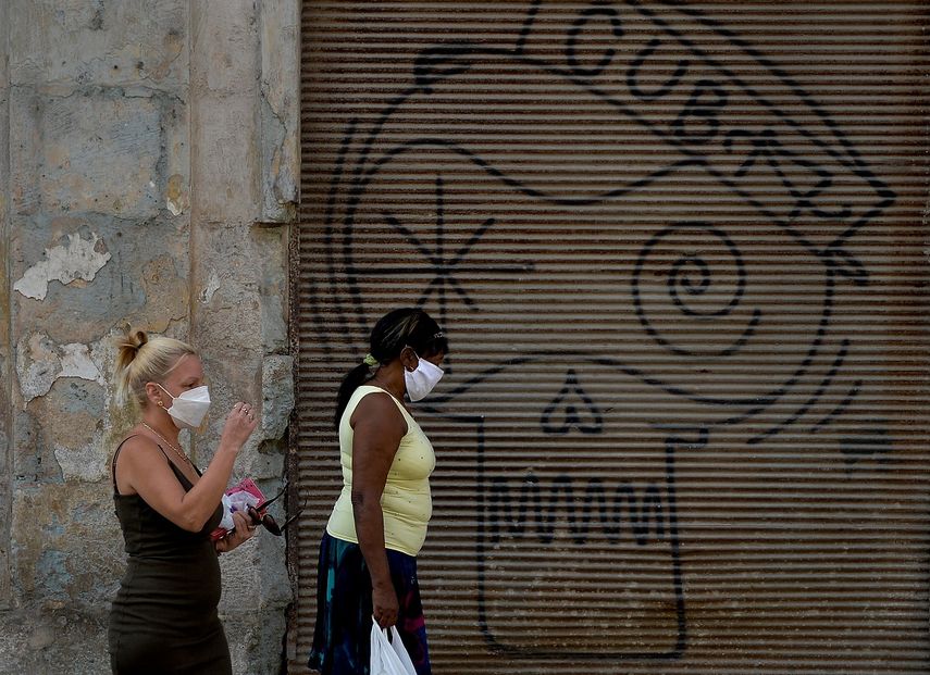 Dos mujeres usan mascarillas mientras caminan por una de las calles de La Habana, en Cuba, el 24 de marzo de 2020.
