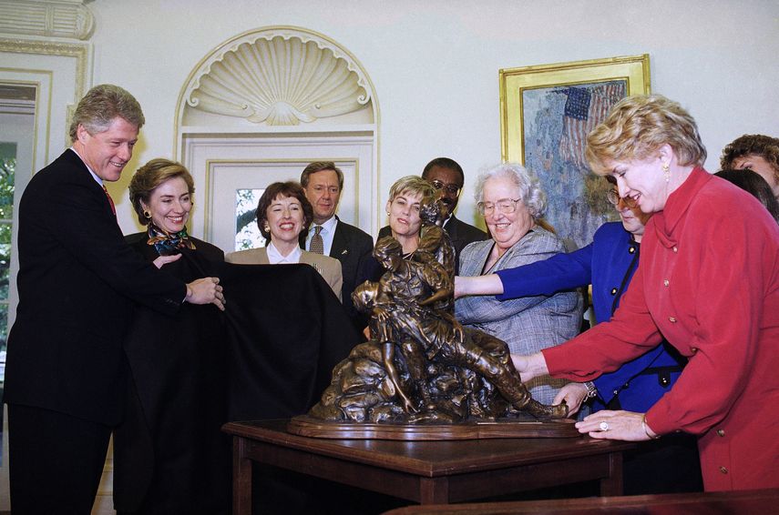 En esta foto del 10 de noviembre de 1993, el presidente Bill Clinton y la primera dama Hillary Rodham Clinton develan una miniatura del Monumento a las Mujeres de la Guerra de Vietnam en la Casa Blanca, en Washington.&nbsp;A la derecha, la escultora Glenna Goodacre, su creadora.