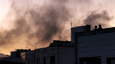 Personas en un tejado en medio de una columna de humo tras un ataque israelí en Teherán, Irán, el 17 de junio de 2025.