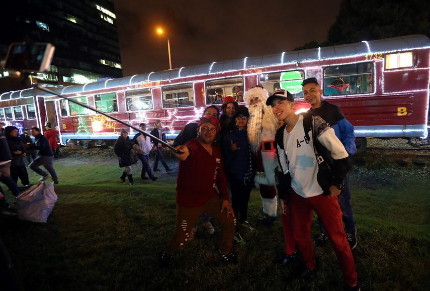 Pasajeros se toman fotos frente al El Tren de la&nbsp;Navidad, en Bogotá (Colombia).&nbsp;