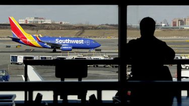 Un avión de Southwest Airlines en la pista de aterrizaje mientras una persona come en un restaurante del aeropuerto LaGuardia en Nueva York.