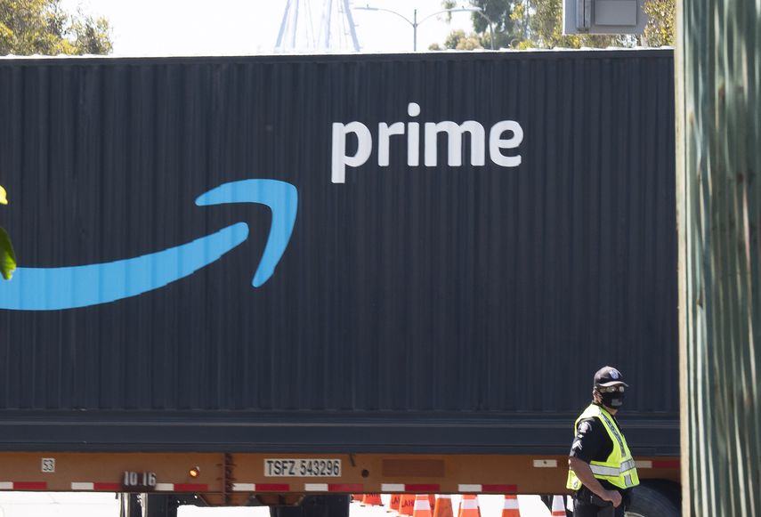 Un hombre pasa frente a un contenedor de mercancias de Amazon Prime.
