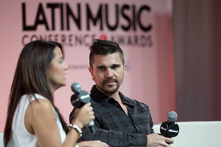 Juanes escucha una pregunta de la presentadora Ingrid Otero durante una sesión de preguntas y respuestas en la Conferencia Billboard de la Música Latina. (AP)