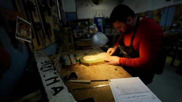 Nikolae (no proporcionó su apellido), un preso de la cárcel de máxima seguridad Opera, trabaja en un violín para La Scala hecho con madera de barcos de inmigrantes en la prisión cerca de Milán, en el norte de Italia el 9 de febrero de 2024.