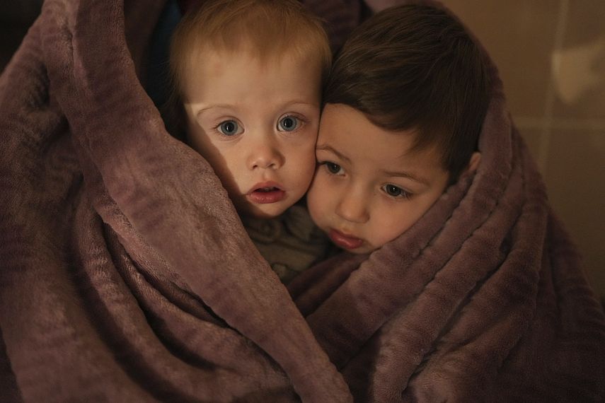 Los hijos de trabajadores médicos se calientan con una manta mientras esperan a sus familiares en un hospital en Mariupol, Ucrania, el viernes 4 de marzo de 2022.&nbsp;