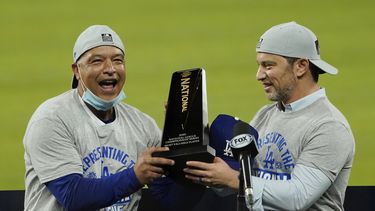 El manager de los Dodgers de Los Ángeles Dave Roberts (izquierda) y el presidente de operaciones de béisbol Andrew Friedman con el trofeo de campeones de la Liga Nacional en Arlington, Texas.