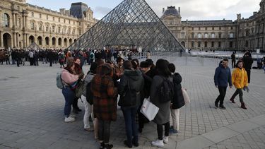Turistas esperan y empleados en huelga se manifiestan en la entrada al Museo del Louvre, Par&iacute;s, viernes 17 de enero de 2020. El museo estaba cerrado en medio de huelgas contra el plan del gobierno de reformar el sistema jubilatorio.&nbsp;