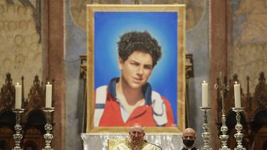 Una imagen de Carlo Acutis, un ni&ntilde;o italiano de 15 a&ntilde;os que muri&oacute; en 2006 de leucemia, se ve durante la ceremonia de beatificaci&oacute;n celebrada por el cardenal Agostino Vallini, en el centro, en la Bas&iacute;lica de San Francisco, en As&iacute;s, Italia, el s&aacute;bado 10 de octubre. 10, 2020.
