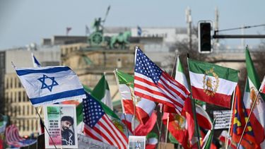 Los manifestantes ondean la bandera iraní de la revolución preislámica de 1979 y las banderas nacionales de Israel y de los Estados Unidos durante una manifestación Libertad para Irán mientras se ve la cuadriga en la parte superior de la Puerta de Brandeburgo al fondo en Berlín, Alemania, el 28 de febrero de 2026.