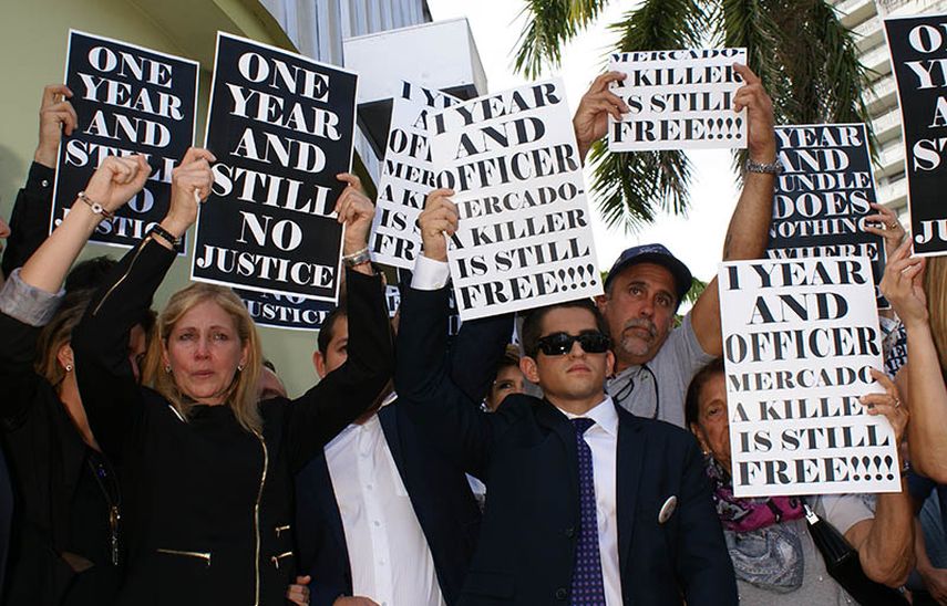 La madre de Israel Hernández sostiene un cartel pidiendo justicia el miércoles durante la vigilia en Miami Beach. (Frank Díaz Donikián)