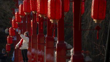 Una mujer se toma una selfie en un puente decorado con linternas en un parque pública en Beijing en el primer día de la fiesta del Año Nuevo Lunar, el domingo 22 de enero de 2023.&nbsp;