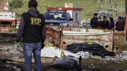 Un miembro del Ministerio Público se encuentra cerca de los cadáveres después de una estampida después de un concierto por el día de la independencia de Guatemala en Quetzaltenango, 200 km al oeste de la Ciudad de Guatemala, el 15 de septiembre de 2022.