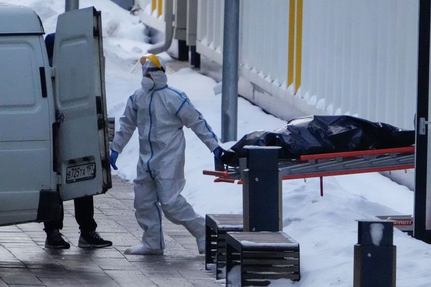 Trabajadores hospitalarios llevan un cadáver a una camioneta fuera de un hospital en Kommunarka, en las afueras de Moscú en Rusia, el 27 de enero del 2022.&nbsp;