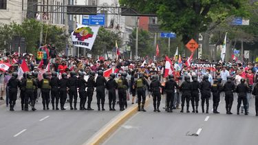 Manifestantes antigobierno que viajaron a la capital desde otras partes del país se enfrentan a una línea de policías antimotines en una marcha contra la presidenta peruana Dina Boluarte en Lima, Perú, el miércoles 18 de enero de 2023.