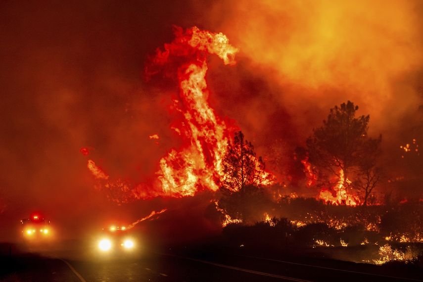 Las llamas saltan sobre los vehículos de bomberos mientras el incendio Park consume la autopista 36 cerca de Paynes Creek, en el condado de Tehama, California, el viernes 26 de julio de 2024.&nbsp;