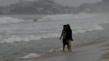 Dos personas observan el fuerte oleaje después de la alerta de llegada del huracán a Acapulco, estado de Guerrero, México, el 24 de octubre de 2023. Archivo.