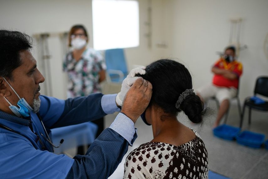 Un médico realiza terapia de acupuntura en una paciente de COVID-19 en recuperación en un centro de salud administrado por el gobierno en el barrio Coche de Caracas, Venezuela, el jueves 25 de febrero de 2021.
