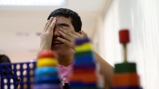 Un niño con autismo juega en durante una clase de aprendizaje básico.