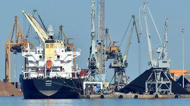 Trabajadores realizan embarque con grúas en el puerto para exportar la producción.