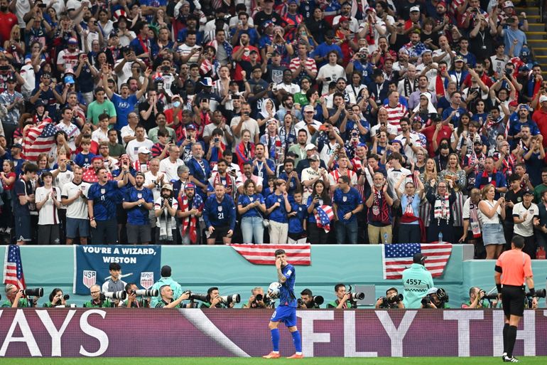 El delantero de Estados Unidos, Christian Pulisic, sostiene el balón frente a la afición norteamericana en el encuentro contra Inglaterra en el Mundial de Catar.