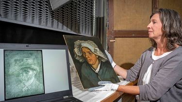 Una imagen distribuida por las Galerías Nacionales de Escocia el 14 de julio de 2022 muestra a la conservadora senior Lesley Stevenson viendo Cabeza de una mujer campesina junto a una imagen de rayos X de un autorretrato oculto del pintor holandés Vincent Van Gogh en Edimburgo.