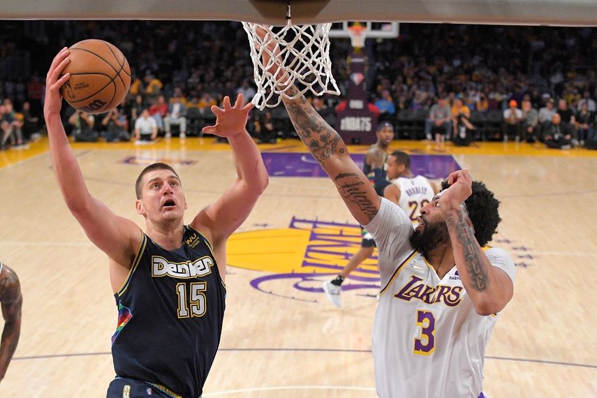 Nikola Jokic, izquierda, de los Nuggets de Denver, dispara ante la presión de Anthony Davis, de los Lakers de Los Ángeles, durante la primera mitad del juego de baloncesto de la NBA