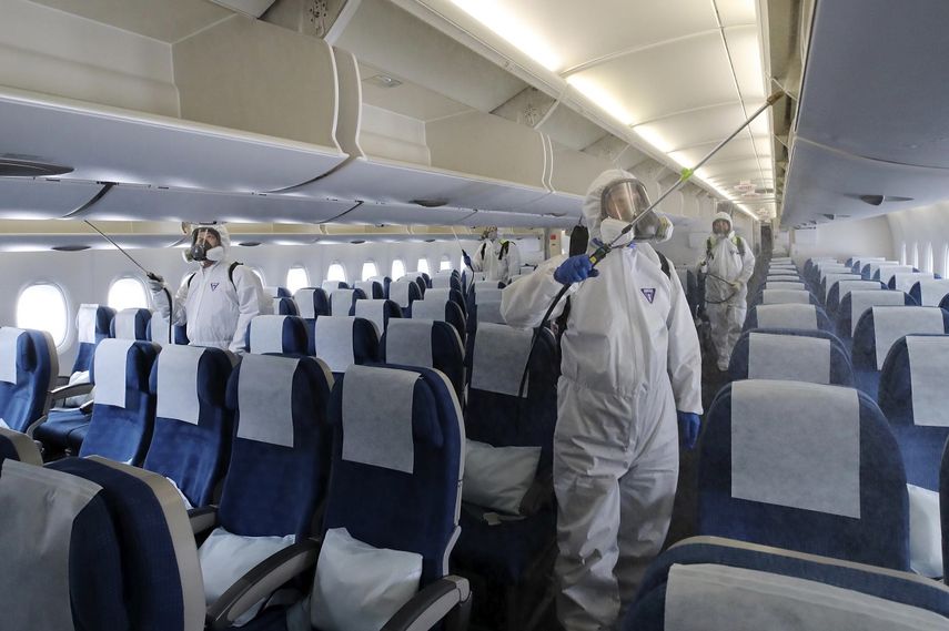 Trabajadores con trajes protectores roc&iacute;an desinfectante dentro de un avi&oacute;n con destino a Nueva York como medida de precauci&oacute;n contra el nuevo coronavirus, en el Aeropuerto Internacional de Incheon, Corea del Sur, el mi&eacute;rcoles 4 de marzo de 2020.