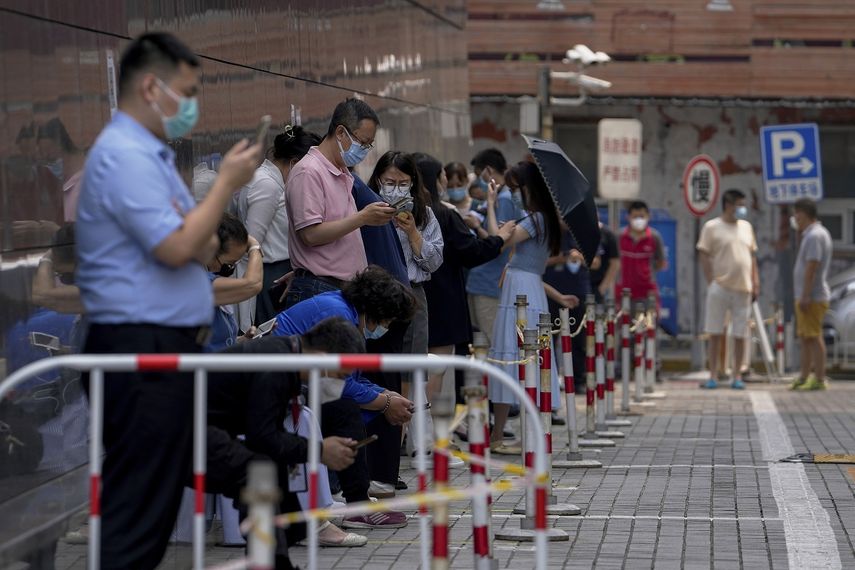 Gente con mascarillas espera en fila para hacerse pruebas de COVID-19 en Pekin, el jueves 16 de junio de 2022. AP -Andy Wong