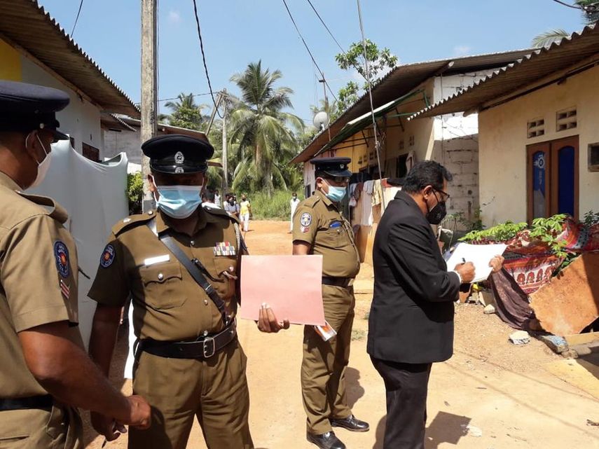 El magistrado de Sri Lanka Wasantha Ramanayake, a la derecha, y agentes de policía inspeccionan el exterior de una casa donde una niña de nueve años fue muerta en lata en Delgoda, Sri Lanka, el domingo 28 de febrero de 2021.&nbsp;