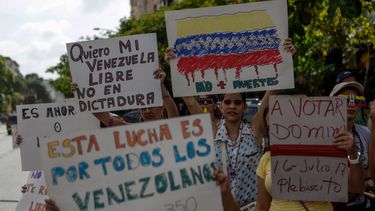 &nbsp;Simpatizantes de la oposición muestran carteles exigiendo un cambio de Gobierno en Venezuela.&nbsp;