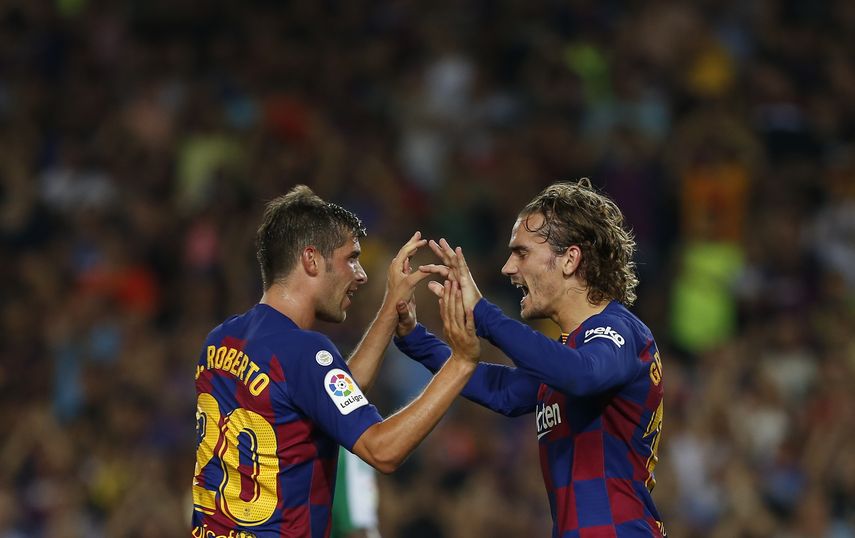 Antoine Griezmann (derecha) festeja tras anotar el primer gol del Barcelona junto a su compañero Sergi Roberto en el partido ante el Real Betis por la Liga española, el domingo 25 de agosto de 2019