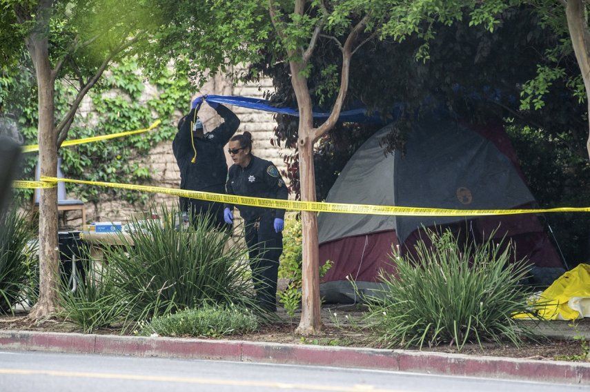 Policías investigan en el lugar en donde una indigente fue apuñalada varias veces a través de un costado de su tienda de campaña cerca de las calles 2nd y L, el martes 2 de mayo de 2023, en Davis, California.&nbsp;