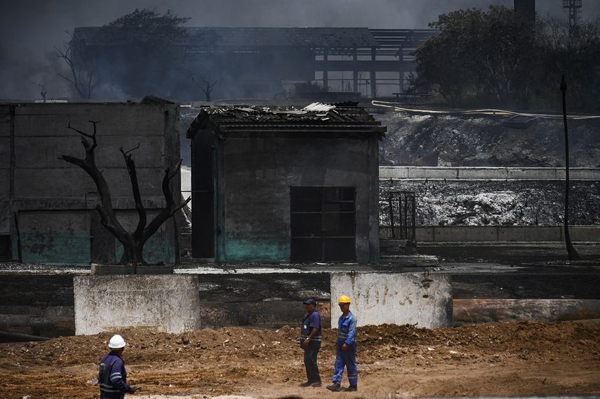 Miembros de la mayor empresa petrolera de Cuba, Cuba Oil Union (Cupet), inspeccionan los daños en el depósito de combustible que estuvo en llamas durante cinco días después de que un rayo cayera sobre uno de sus tanques, en Matanzas, Cuba, el 10 de agosto de 2022.&nbsp;&nbsp;