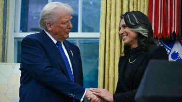 El presidente Donald Trump saluda de mano a Tulsi Gabbard después de que ella fue investida como Directora de Inteligencia Nacional (DNI) en la Oficina Oval de la Casa Blanca en Washington, DC, el 12 de febrero de 2025.