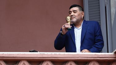 El futbolista Diego Maradona sostiene una peque&ntilde;a r&eacute;plica de la Copa Mundial de la FIFA mientras la besa frente a los fan&aacute;ticos en la casa del gobierno despu&eacute;s de su reuni&oacute;n con el presidente argentino Alberto Fern&aacute;ndez en Buenos Aires, Argentina, el jueves 26 de diciembre de 2019.&nbsp;