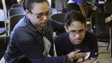La hondureña Mariela Sánchez consuela a su hijo Jonathan, de 16 años, para quien buscan tratamiento médico en EEUU por su padecimiento de fibrosis quística, durante una conferencia de prensa el lunes 26 de agosto del 2019 en Boston.
