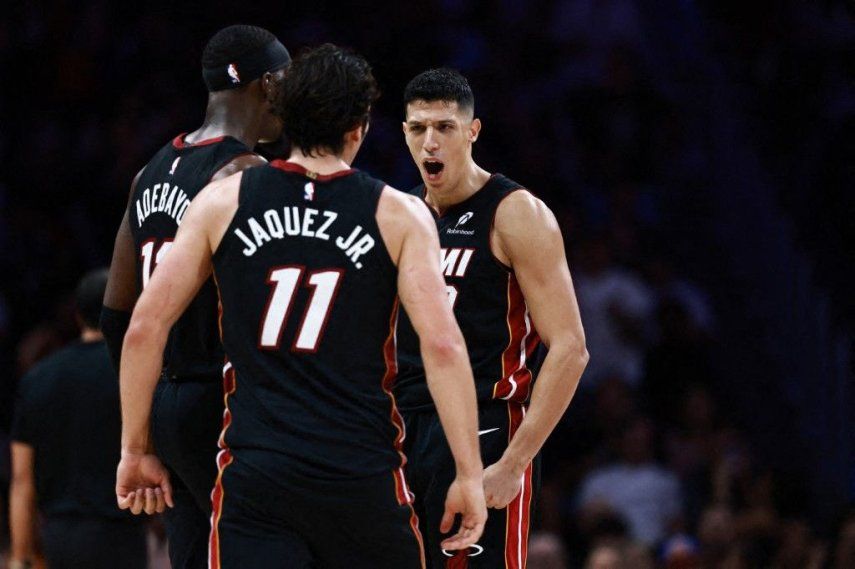 Simone Fontecchio #0 del Miami Heat reacciona con sus compañeros Jaime Jaquez Jr. #11 y Bam Adebayo #13 contra los New York Knicks durante la segunda mitad en el Kaseya Center el 26 de octubre de 2025 en Miami, Florida.&nbsp;